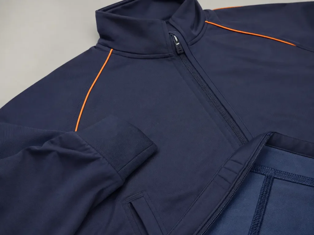 Zipper alignment, pocket reinforcement, cuff recovery and seam finishing are visible indicators to check on the sample.